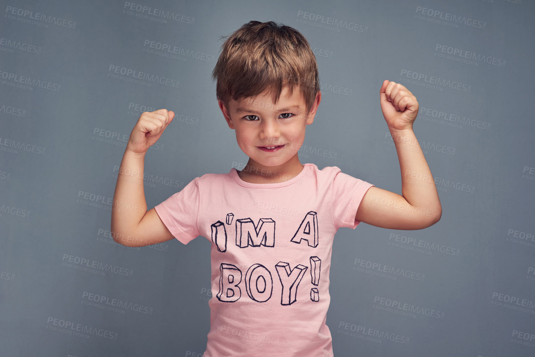 Buy stock photo Studio portrait of a cheering boy wearing a shirt with “I’m a boy” printed on it against a gray background