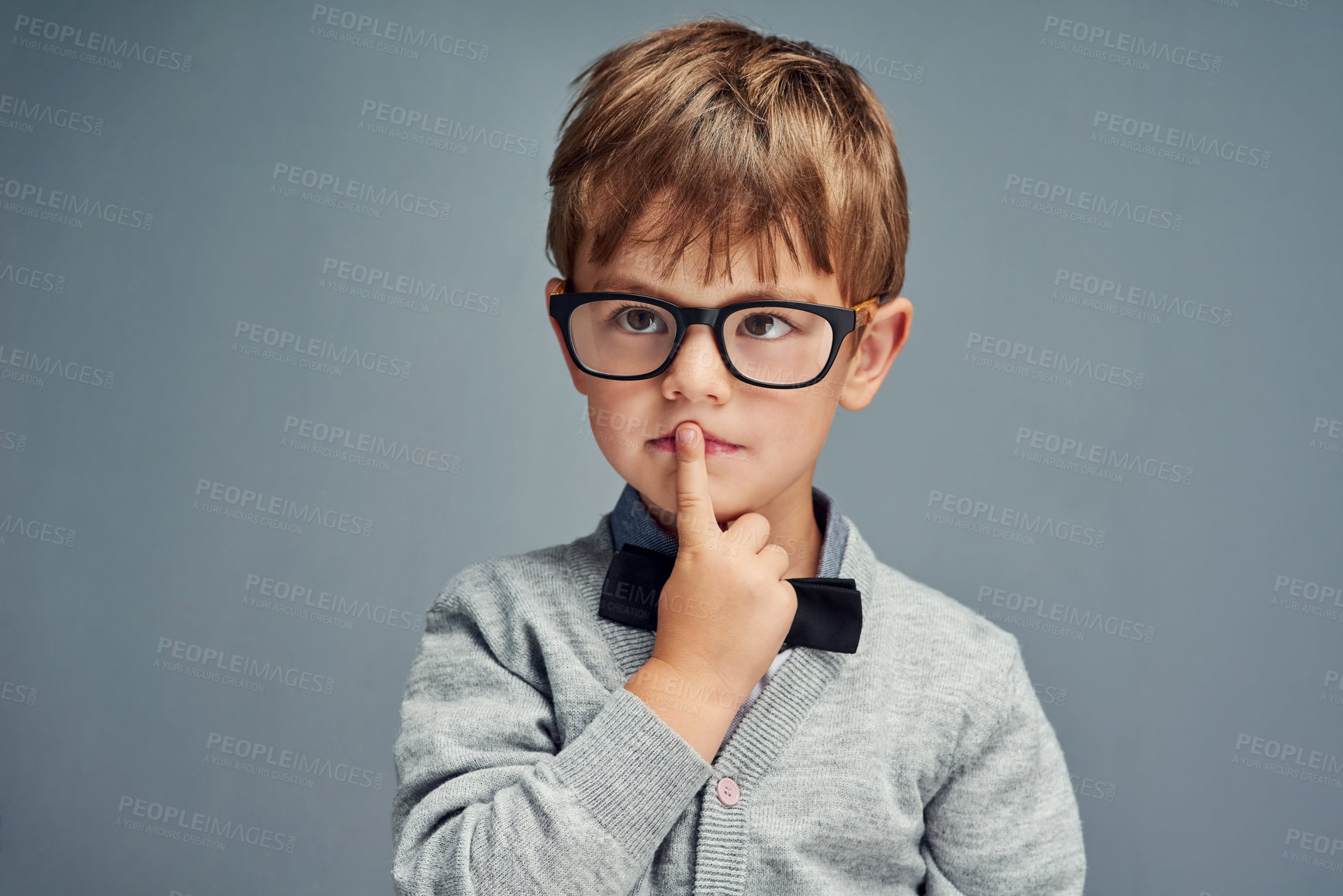Buy stock photo Studio shot of a smartly dressed little boy looking thoughtful against a gray background
