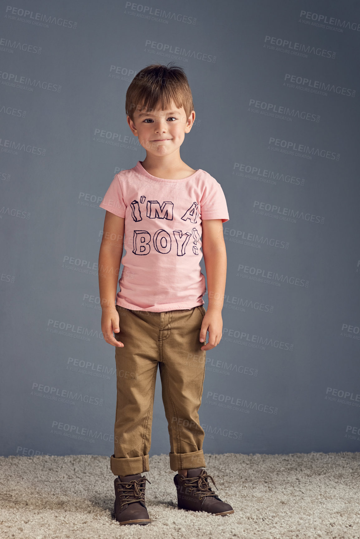 Buy stock photo Fashion, tshirt and portrait of child in studio with trendy style, casual outfit and cool clothes. Happy, smile and isolated kid with words for gender identity, youth and pride on gray background