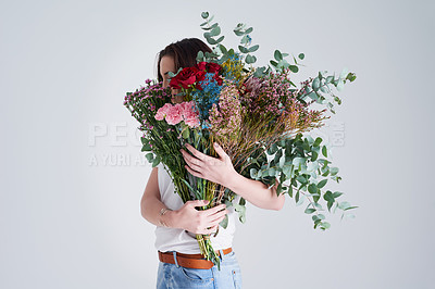 Buy stock photo Nature, hide face and woman with flowers, bouquet or present against a grey background. Female person, model or girl with a floral present, creative aesthetics or natural products with sustainability