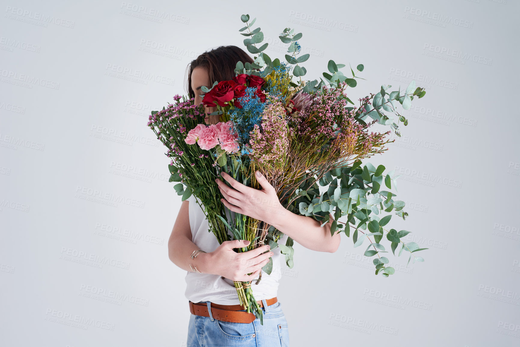 Buy stock photo Nature, hide face and woman with flowers, bouquet or present against a grey background. Female person, model or girl with a floral present, creative aesthetics or natural products with sustainability