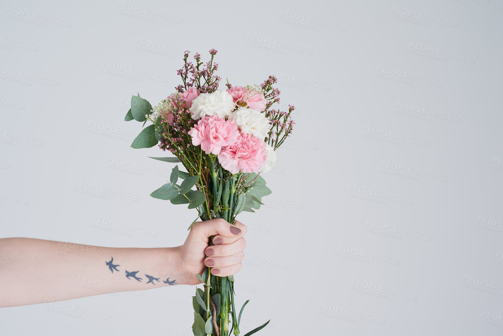 Buy stock photo Studio shot of an unrecognizable woman holding a bouquet of flowers against a grey background