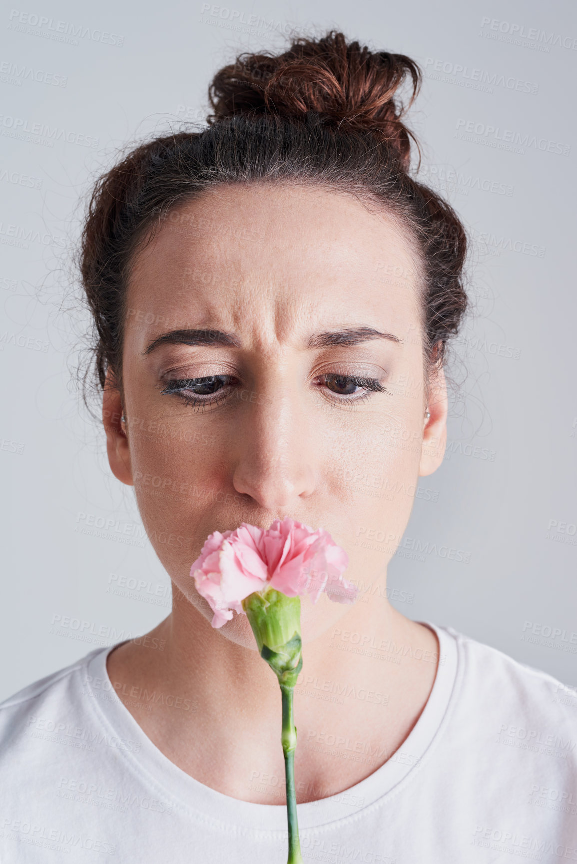 Buy stock photo Studio shot of a beautiful young woman smelling a pink flower against a grey background