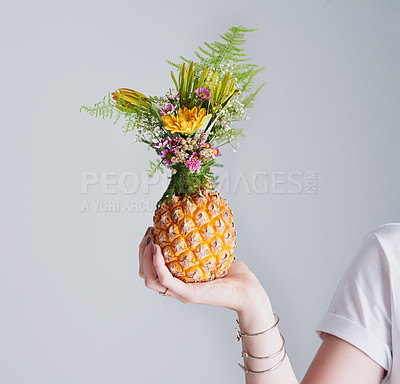 Buy stock photo Studio shot of an unrecognizable woman holding a pineapple against a grey background