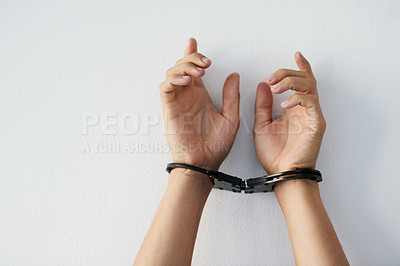 Buy stock photo Cropped shot of a unrecognizable person's hands that are cuffed against a grey background
