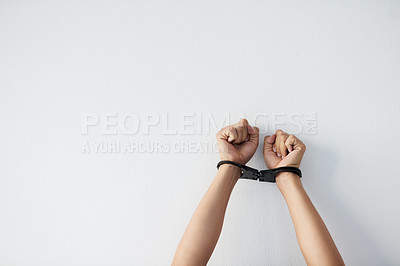 Buy stock photo Cropped shot of a unrecognizable person's hands that are cuffed against a grey background