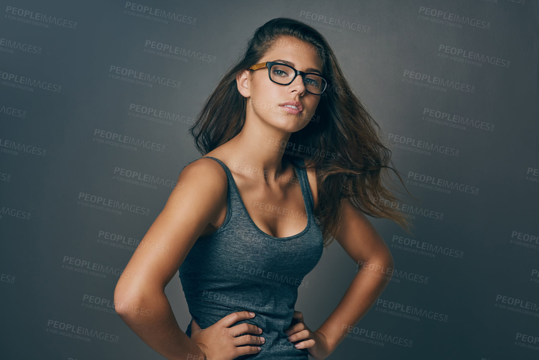 Buy stock photo Studio shot of an attractive young woman striking a pose against a grey background