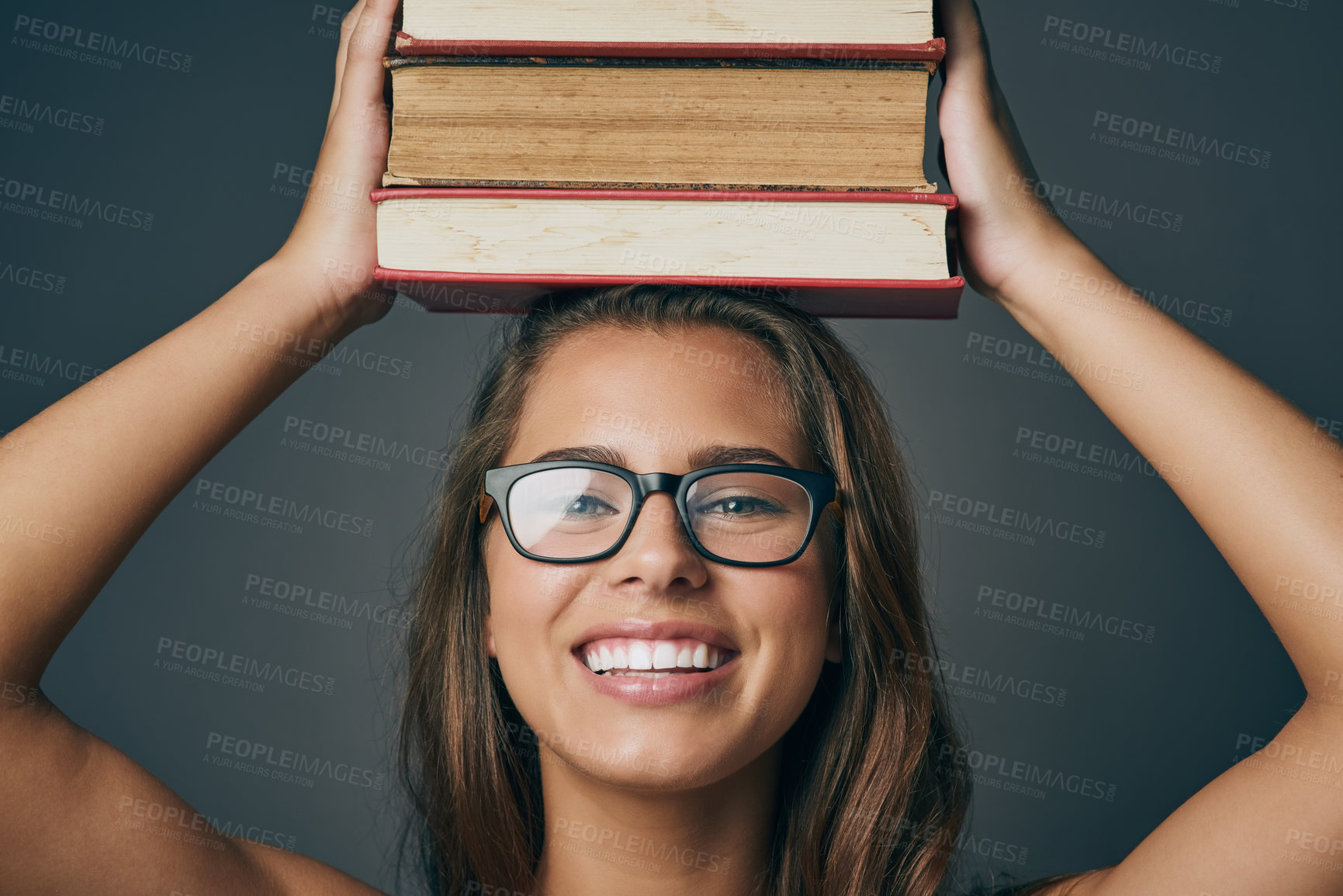 Buy stock photo Portrait, happy woman or balance books on head for learning, education or study isolated on gray studio background. Student, face or textbook stack for knowledge, research or information with glasses