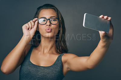 Buy stock photo Woman, confident and selfie with glasses in studio for social media post, eyewear update and prescription for vision. Girl, photography and gray background with spectacles for eye care and optometry.