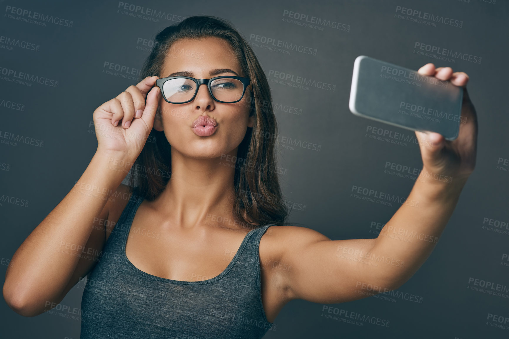 Buy stock photo Woman, confident and selfie with glasses in studio for social media post, eyewear update and prescription for vision. Girl, photography and gray background with spectacles for eye care and optometry.