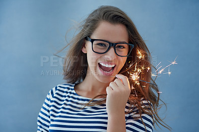 Buy stock photo Happiness, portrait and woman in studio with sparklers isolated on blue background for celebration. Light, glasses and fun birthday event or new year with glow, vision and fireworks with confidence.