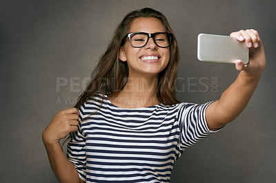 Buy stock photo Woman, glasses and selfie with smile, optometry and confidence on gray studio background. Female person, memory and happy for eyewear, social media and eye care with post, clear vision and frame lens