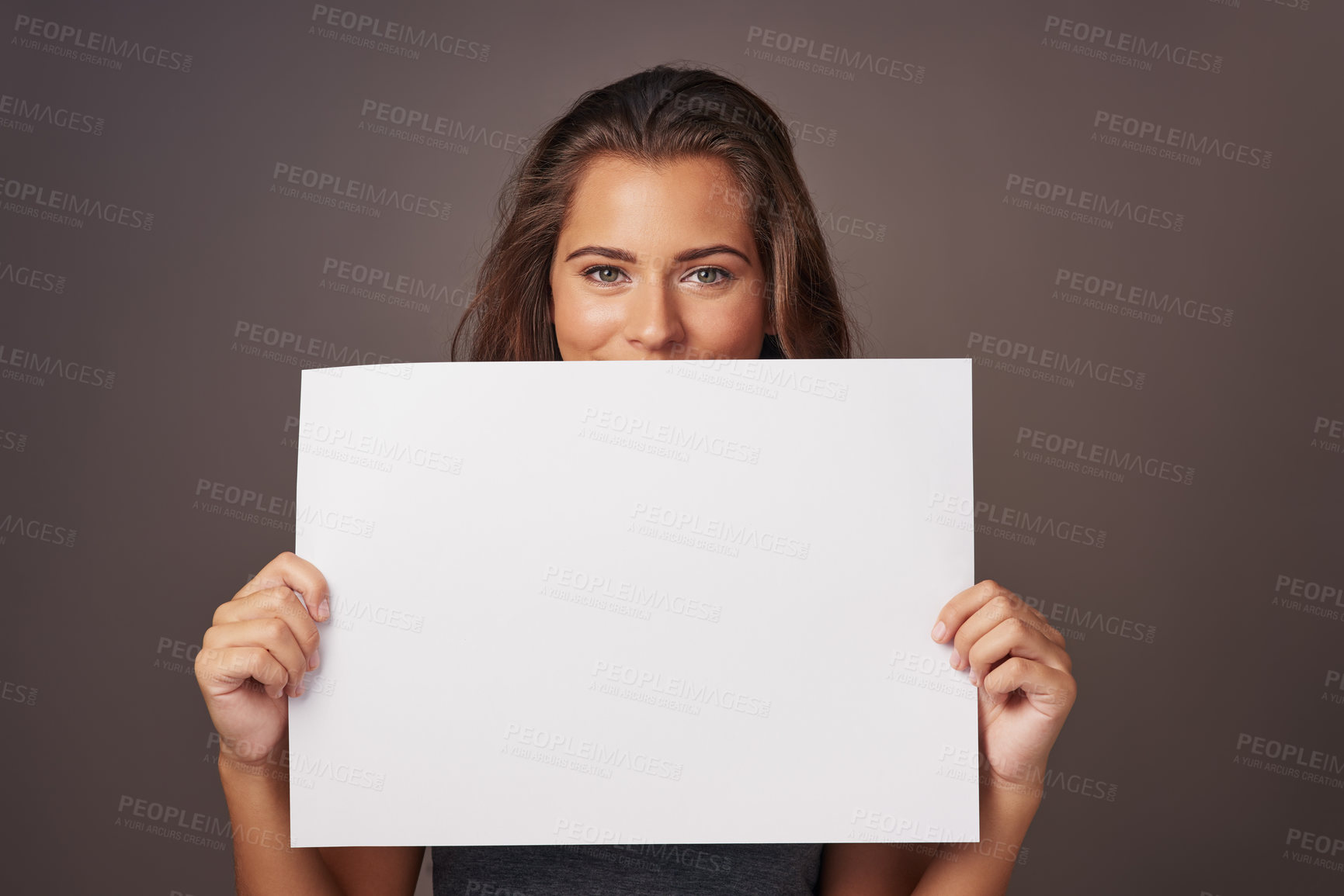 Buy stock photo Studio shot of an attractive young woman holding a blank placard against a gray background