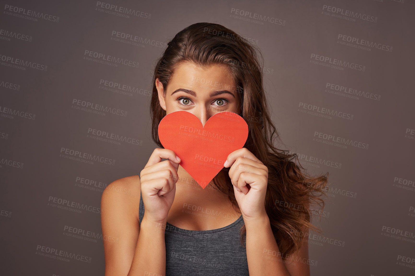 Buy stock photo Portrait, studio and woman with paper heart for romance, support or donate for care isolated on background. Face, love or model with sign for valentines day, kindness or hide on social media emoji