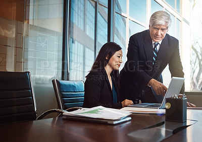 Buy stock photo Cropped shot of a businessman helping a female colleague with something on her laptop