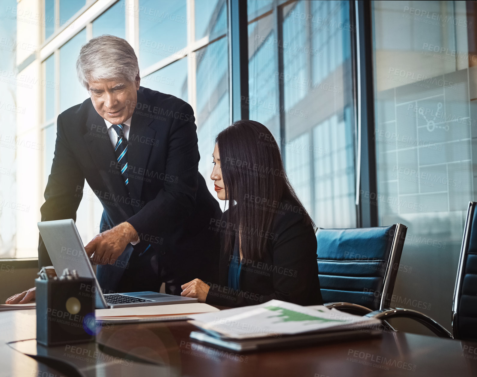 Buy stock photo Cropped shot of a businessman helping a female colleague with something on her laptop