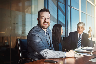 Buy stock photo Cropped portrait of a young businessman sitting in the boardroom during a meeting