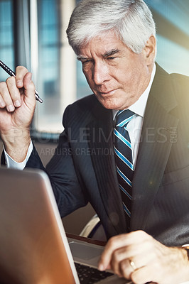 Buy stock photo Cropped shot of a mature businessman working on his laptop in the office