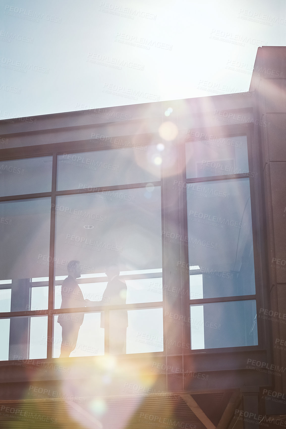 Buy stock photo Low angle shot of two businessman shaking hands in an office corridor