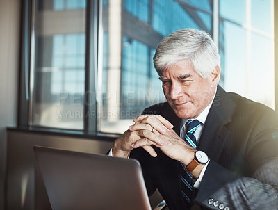 Buy stock photo Cropped shot of a mature businessman working on his laptop in the office