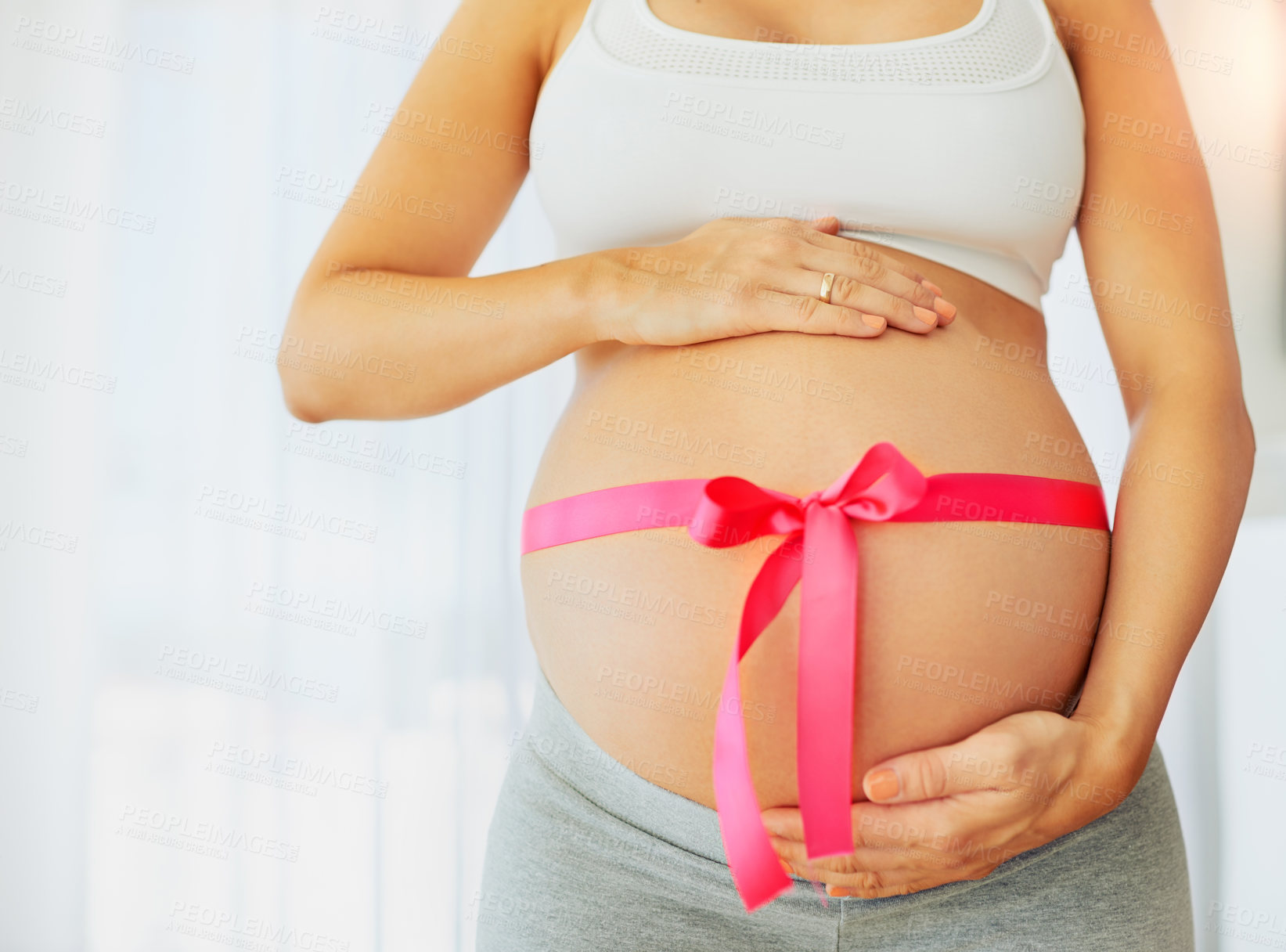 Buy stock photo Hands, pink ribbon and abdomen for pregnant woman in home for gender reveal, symbol or care in morning. Person, mother and fabric for gift, present for baby girl with love and belly in house