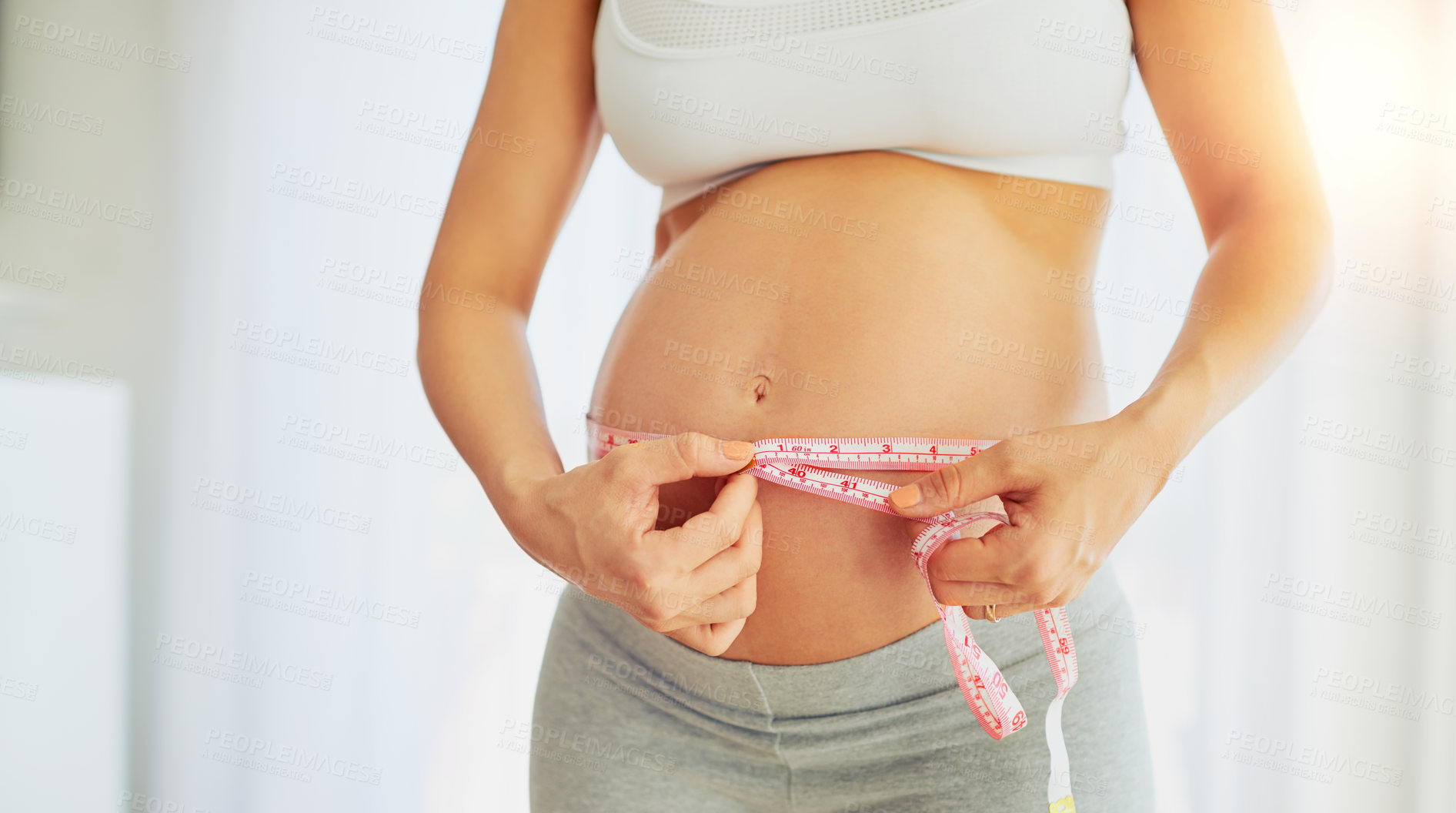 Buy stock photo Pregnant woman, belly and measuring tape for growth, hands and progress in home with body in morning. Person, mother and health check for abdomen, stomach or development with wellness at house