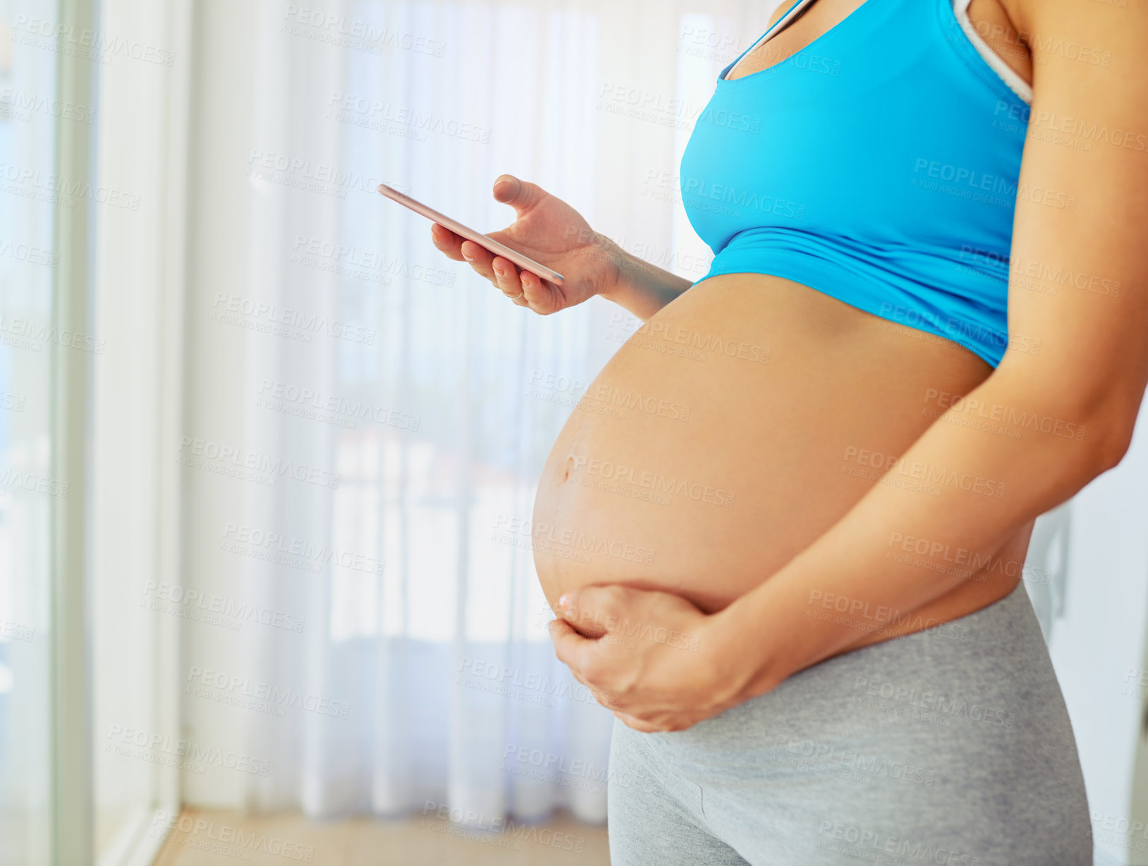 Buy stock photo Pregnant, phone and hands of woman in home for motherhood, health and wellness app in morning. Maternity, pregnancy and stomach of person on smartphone for internet, online shopping and research