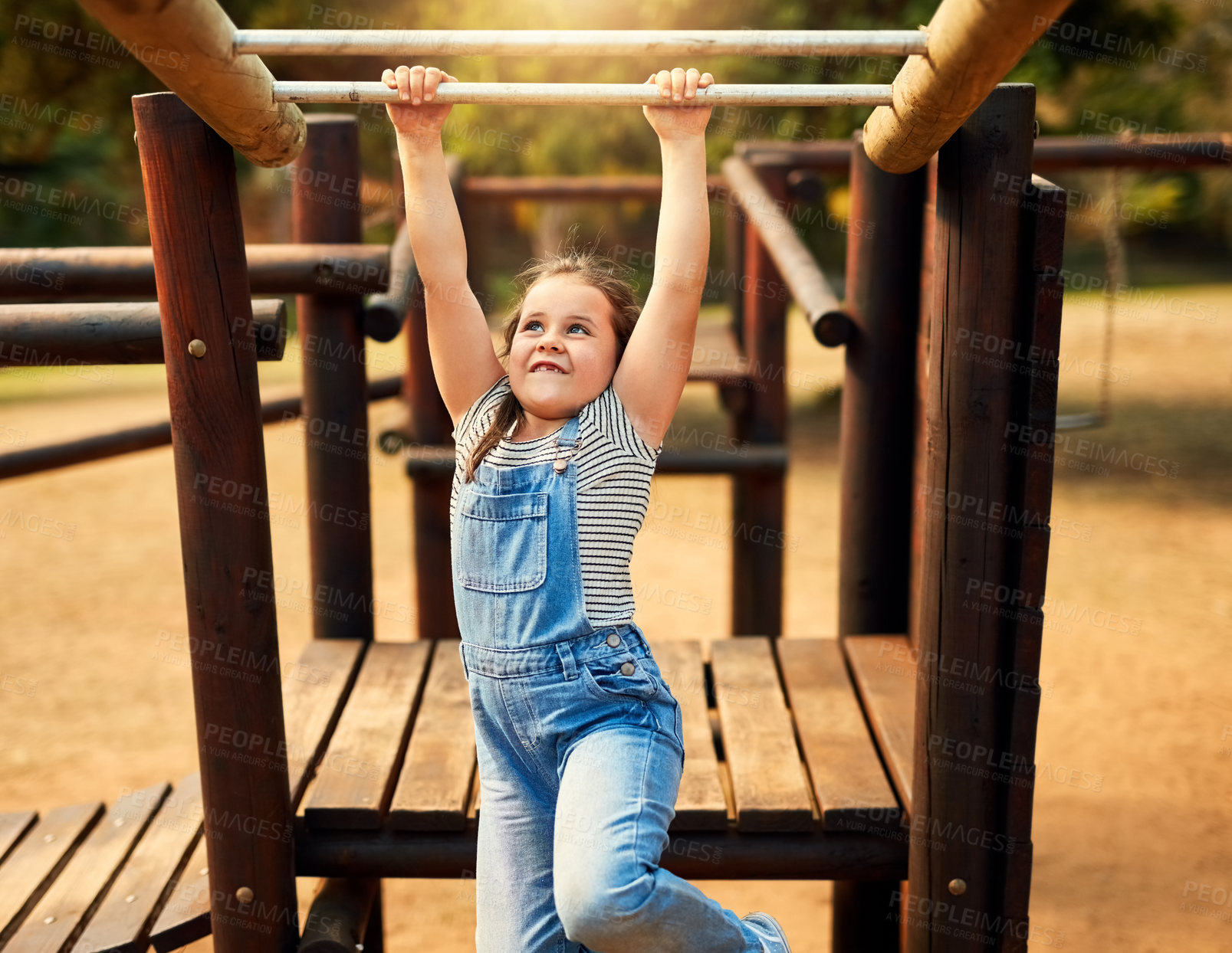 Buy stock photo Shot of a little girl playing on the jungle gym at the park