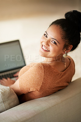 Buy stock photo Shot of a beautiful young woman using a laptop at home