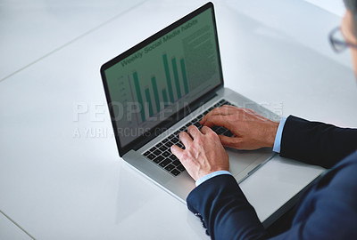 Buy stock photo Cropped shot of an unidentifiable businessman using his laptop at a desk in the office