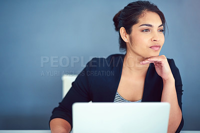 Buy stock photo Shot of a happy young businesswoman working behind her laptop in the office