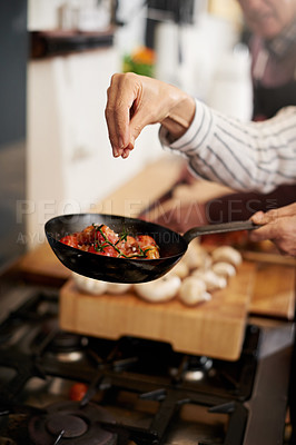 Buy stock photo Hand, cooking and seasoning with a chef in the kitchen for meal preparation in a home for dinner. Healthy, diet and nutrition with food in a pan for wellness, hunger or satisfaction in a house
