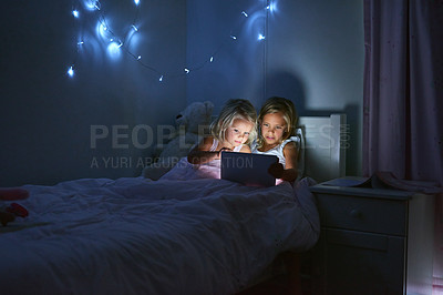 Buy stock photo Tablet, bedroom and children in home at night for streaming movie, video or cartoon together. Digital technology, girls and kids in bed for game, internet addiction and sisters reading story to relax