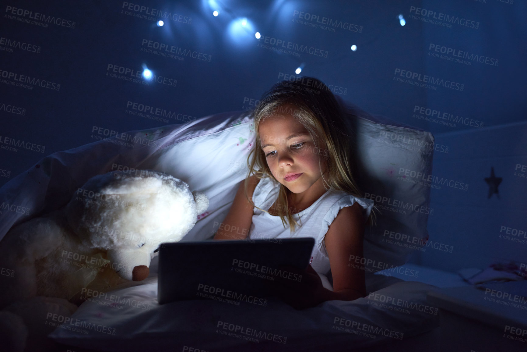 Buy stock photo Shot of a little girl using a digital tablet before bedtime