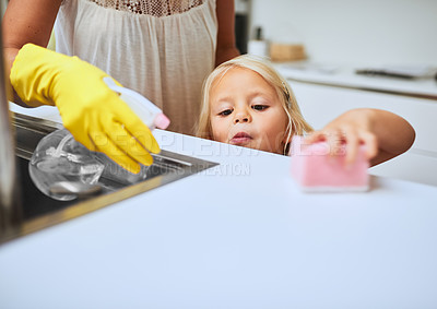 Buy stock photo Shot of a mother and her little daughter cleaning a kitchen surface together at home