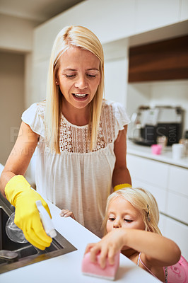 Buy stock photo Mom, girl and sponge for cleaning in kitchen with teaching, bonding and chemical spray in house. Hygiene, mother and daughter child with liquid, bottle and helping hand for bacteria in family home