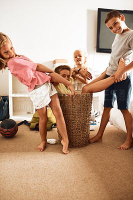 Buy stock photo Portrait, children and laundry basket in home for playing, silly and bonding together with connection. Family, sisters and brothers with happiness for games, creativity and relationship of siblings