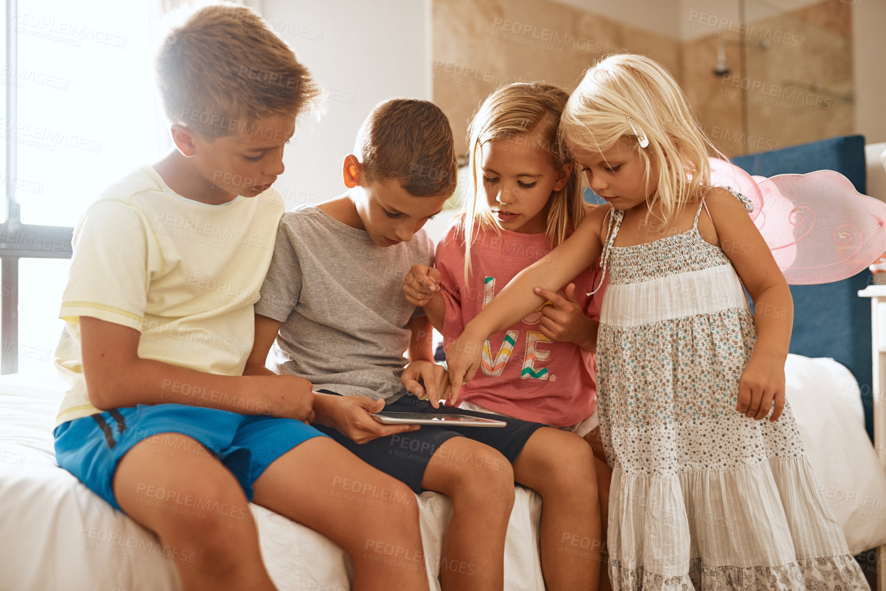 Buy stock photo Shot of little siblings using a digital tablet together at home