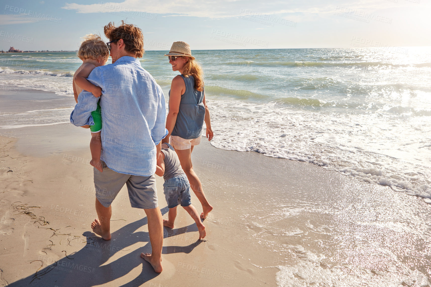 Buy stock photo Holding hands, back and travel with family at beach for trust, connection and summer vacation. Bonding, support and walking with parents and children outdoor for love, commitment and tropical holiday