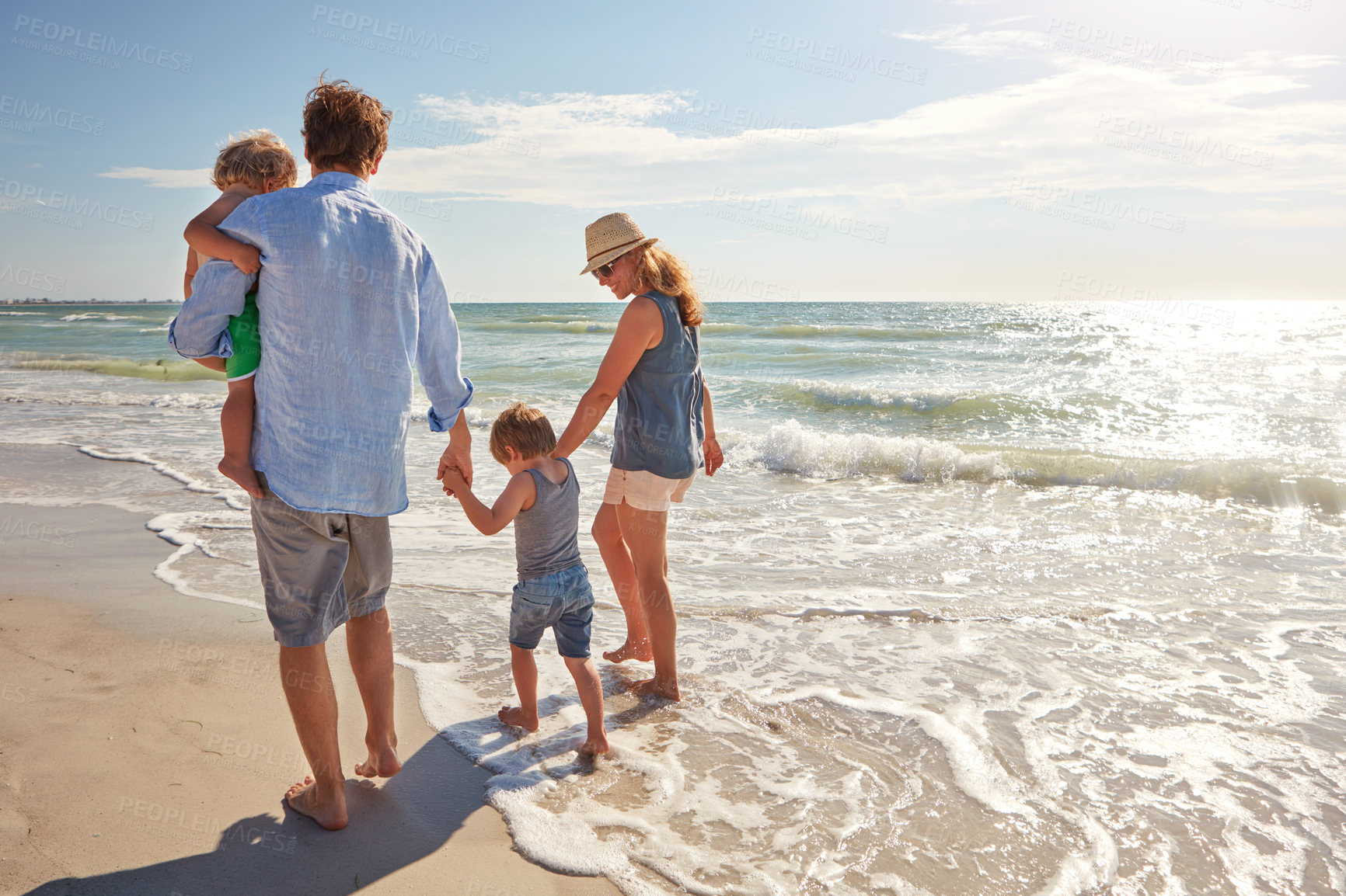 Buy stock photo Holding hands, back and love with family at beach for trust, connection and summer vacation. Bonding, support and walking with parents and children outdoor for travel, commitment and holiday space