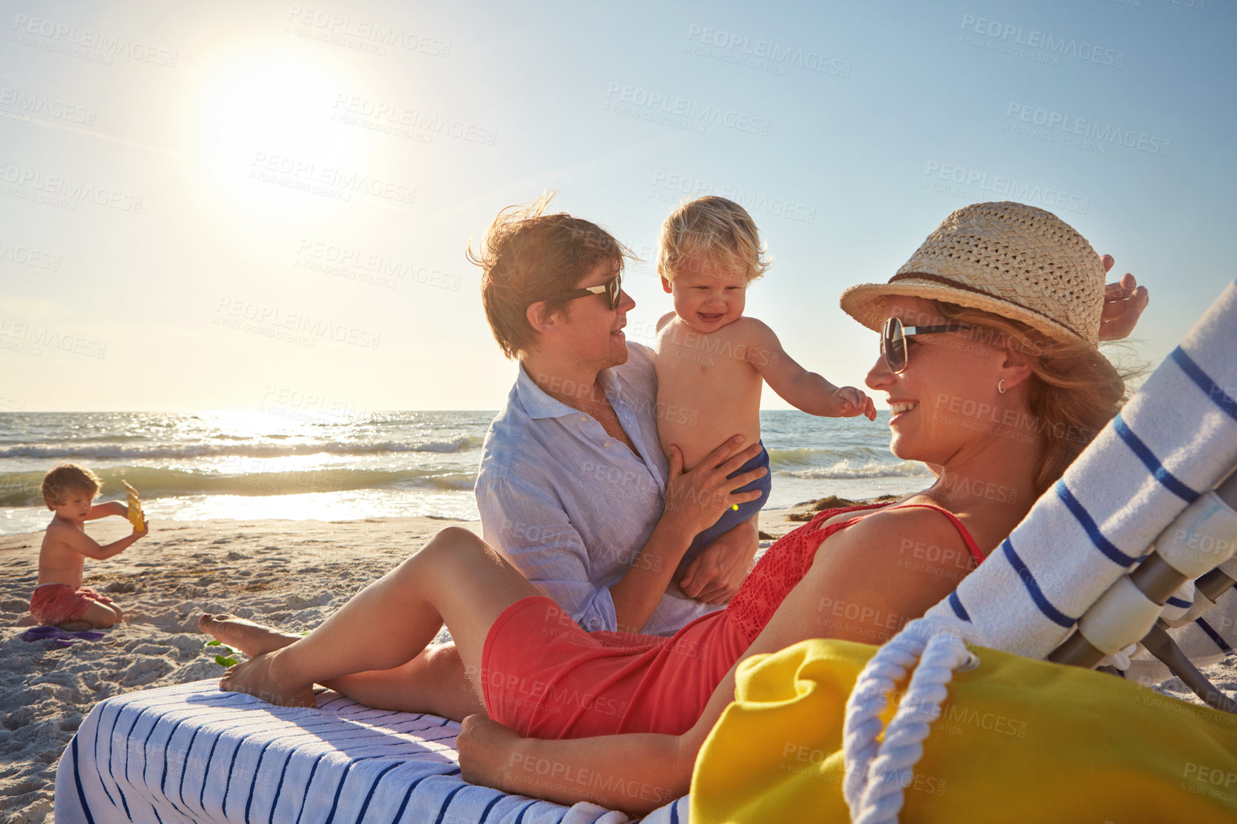 Buy stock photo Chair, sunset or family with woman at beach on holiday vacation or weekend together with dad or kids. Father, calm mother or children siblings at sea for bonding or break in nature in Spain in summer