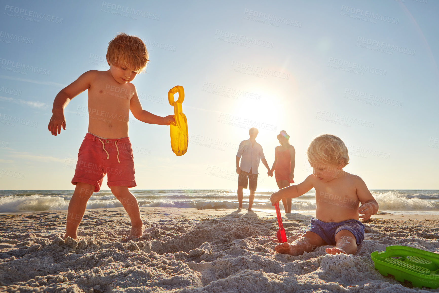 Buy stock photo Beach, family and children with toys for sand castle for child development in summer for holiday, travel or vacation. Mother, father and happy kids together outdoor on coast for adventure or bonding