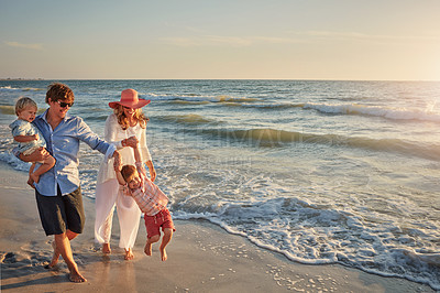 Buy stock photo Family, parents and playing with kids on beach for bonding, outdoor holiday or weekend in nature. Mom, father or children enjoying water for embrace, love or care in sunshine by ocean coast or sea