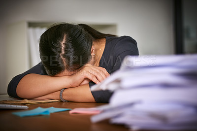 Buy stock photo Shot of an unidentifiable businesswoman lying on her arms next to a pile of paperwork in the office