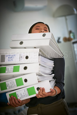 Buy stock photo Portrait of a hardworking businesswoman struggling to carry a heap of files in the office