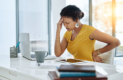 Buy stock photo Shot of a young designer suffering with a headache and back pain in an office