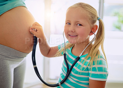Buy stock photo Portrait of a little girl using a stethoscope to listen to her mother's pregnant belly at home
