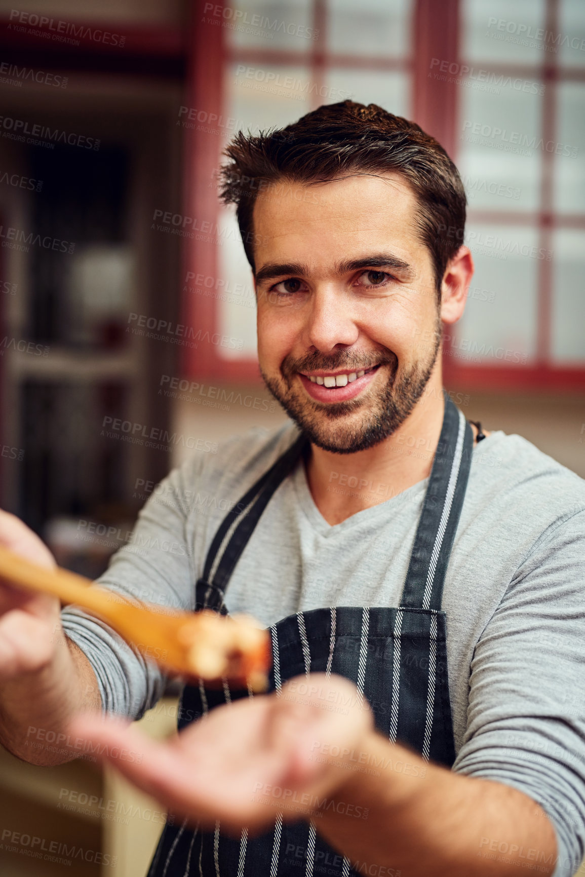 Buy stock photo Shot of a young man cooking in the kitchen