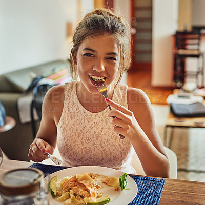 Buy stock photo Shot of a young woman eating food at the dining room table at home