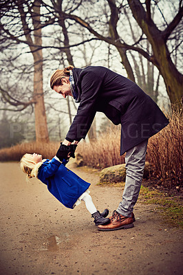 Buy stock photo Shot of a father and daughter being playful outdoors